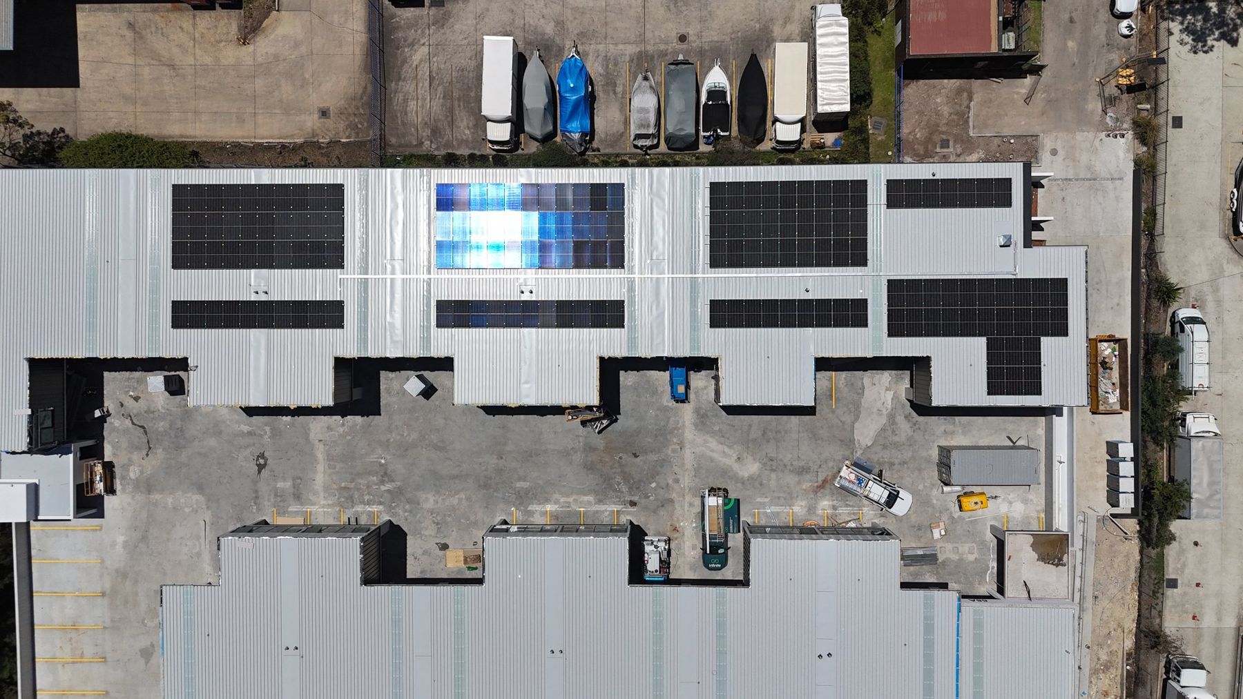Aerial view of a completed commercial rooftop solar install on an industrial building