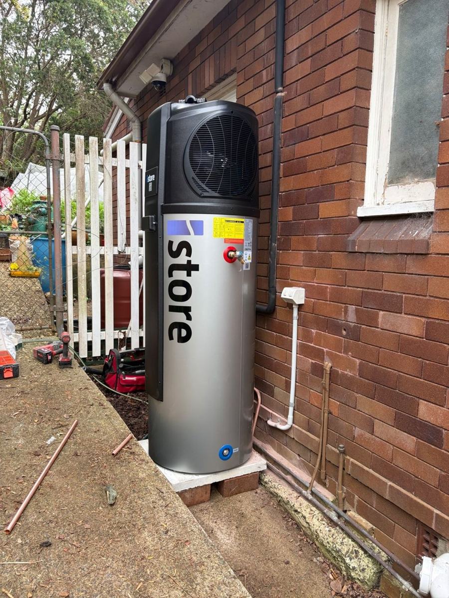 iStore heat pump hot water unit installed beside a brick home