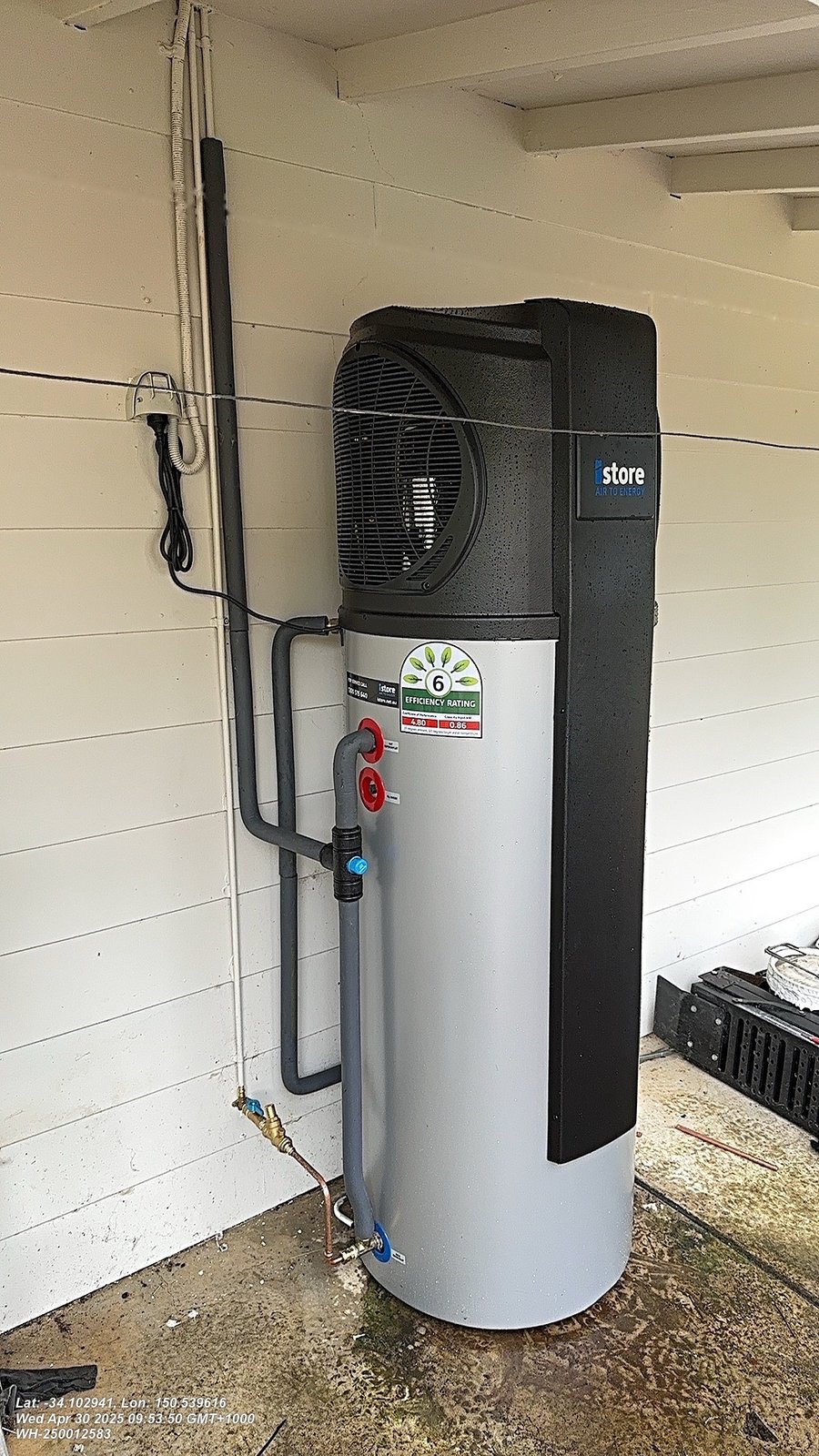 iStore heat pump hot water unit installed against an exterior wall