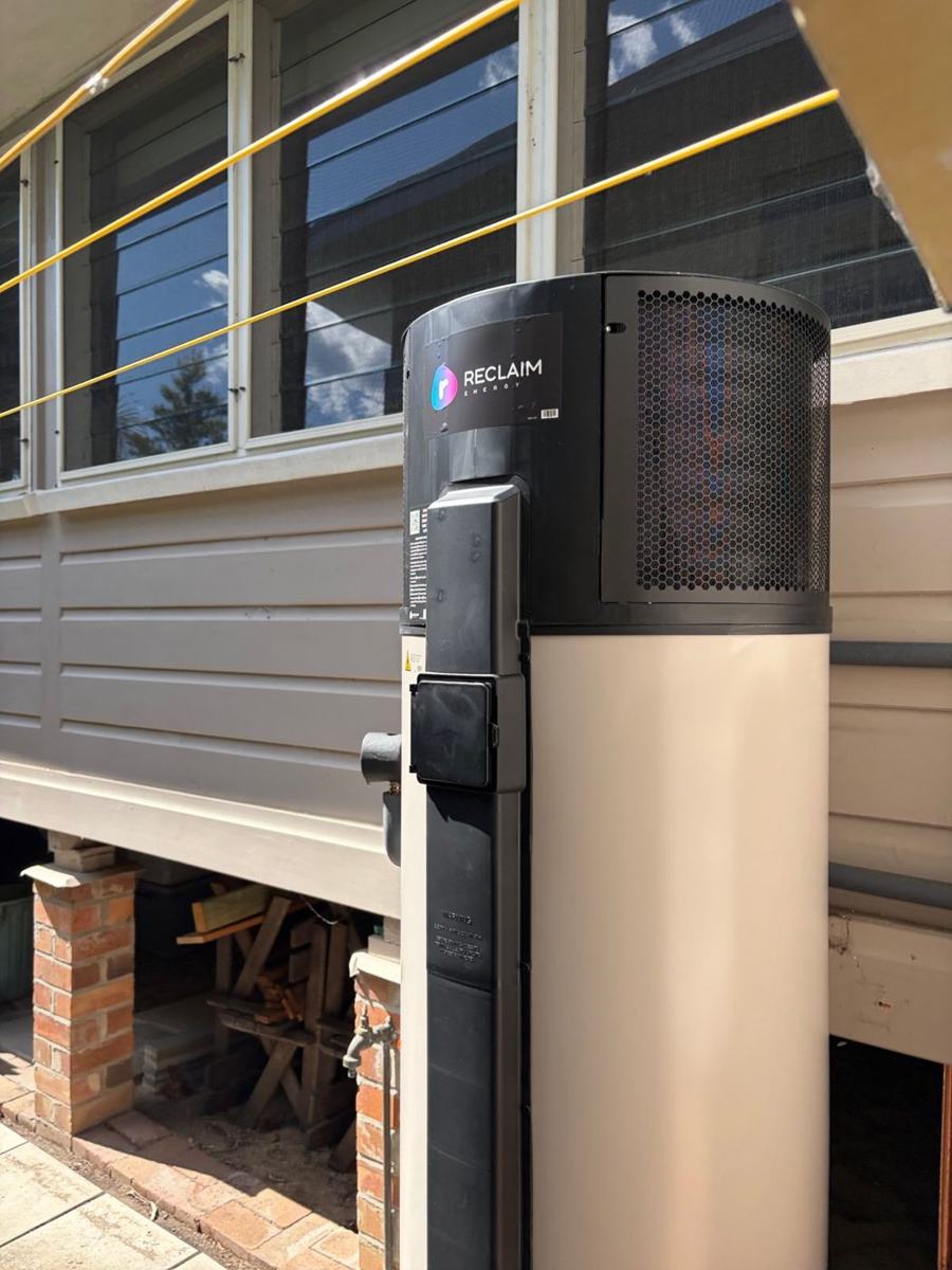 Reclaim Energy heat pump hot water unit installed beside a weatherboard home